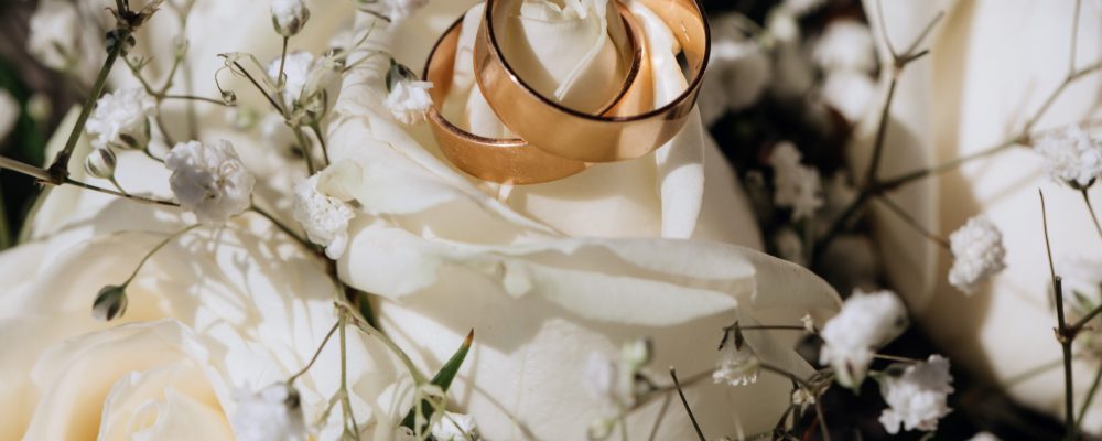 Golden wedding rings on the white rose  from the wedding bouquet